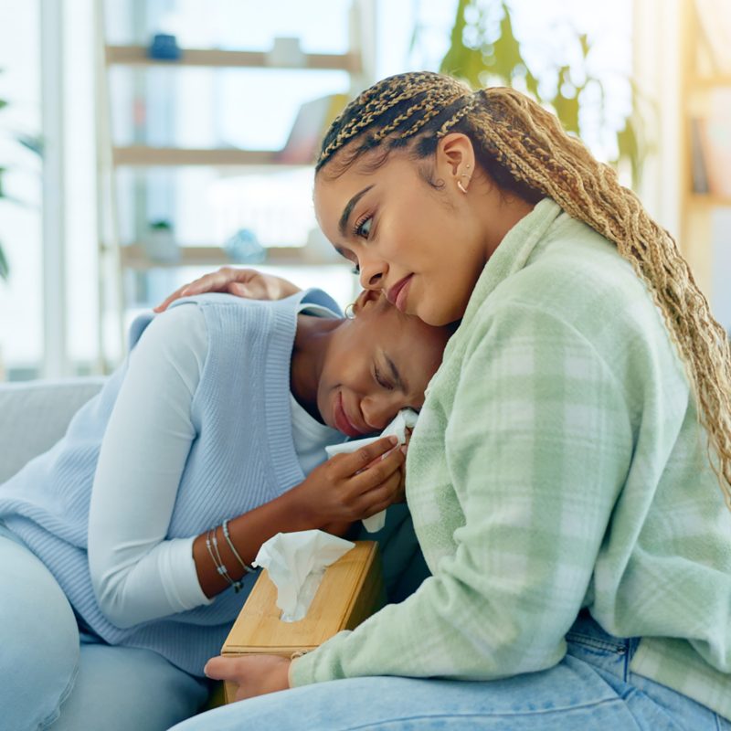 Sad black woman, friends and cry on sofa in support, care or understanding together at home. Africa.