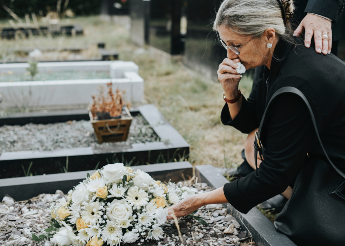 old-woman-laying-flowers-on-a-grave-2026-03-18-11-01-28-utc